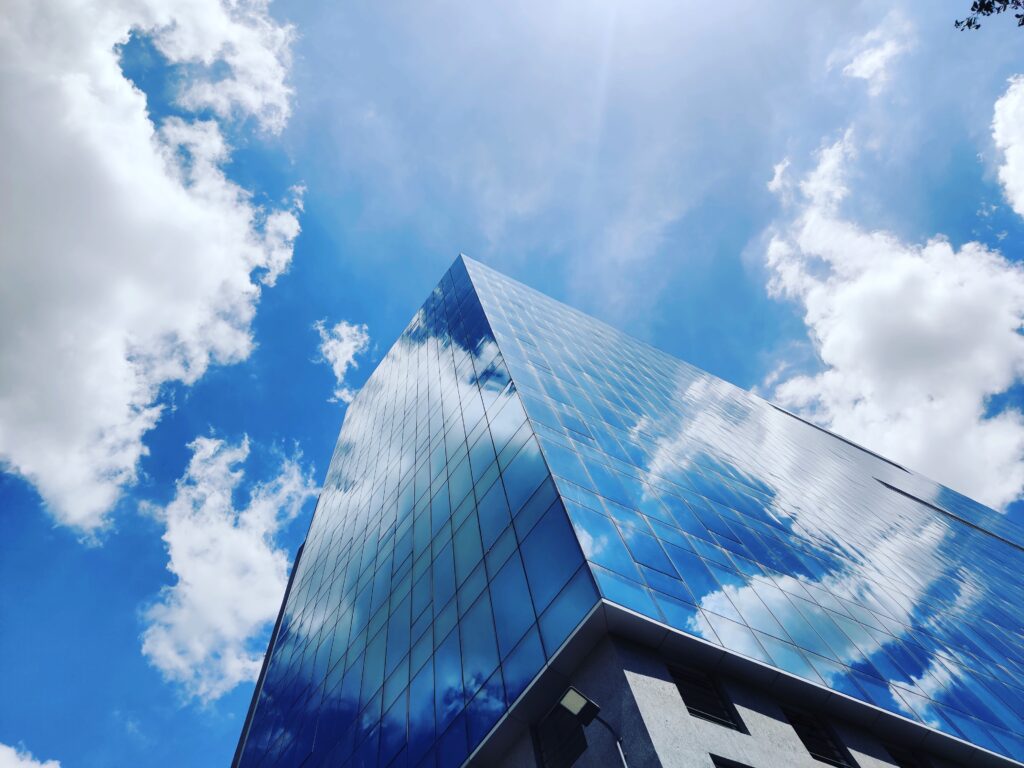 low angle shot of a glass building and blue sky